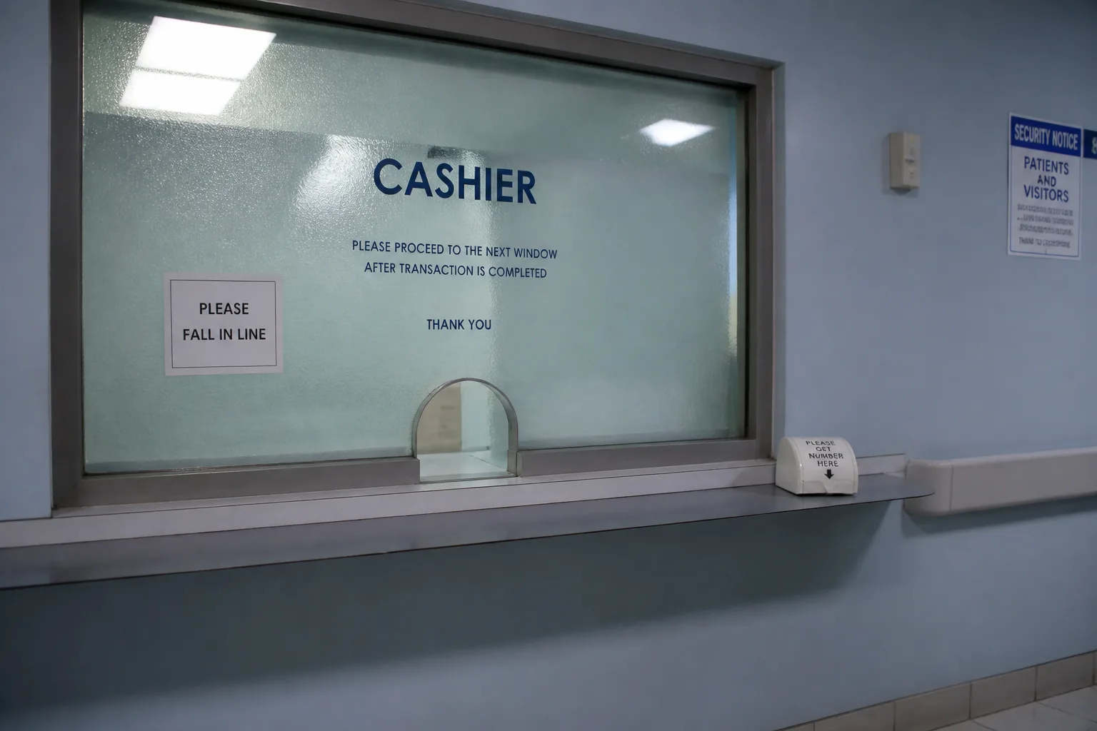 Hospital cashier window with frosted glass and a ticket dispenser